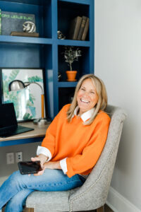 woman in an orange sweater laughing during her realtor branding session