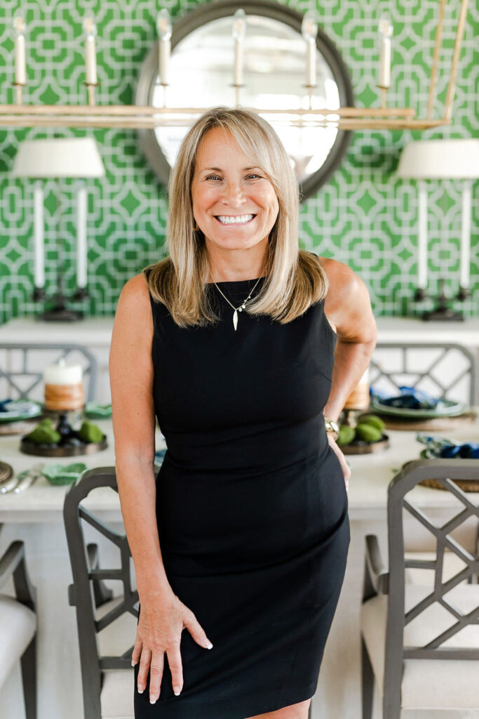 headshot of a woman in a black dress in a dining room