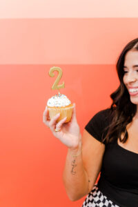 woman holding a cupcake with the number 2