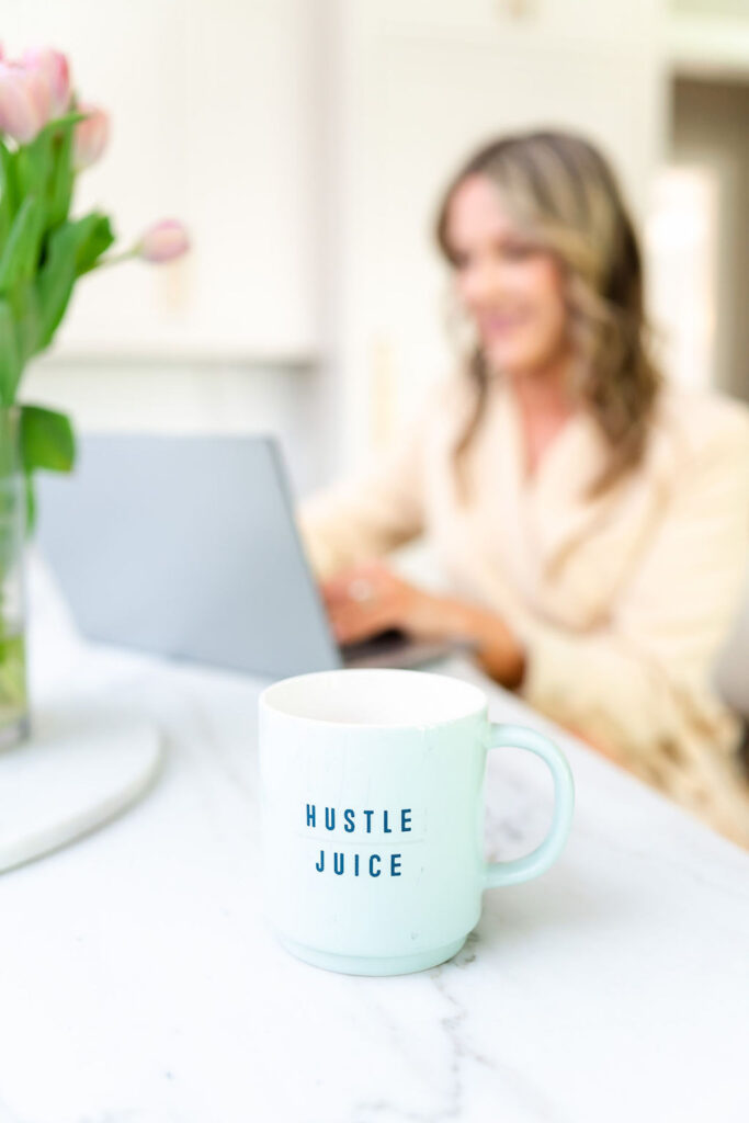 detail shot of a mug with a real estate agent in the background working on her laptop