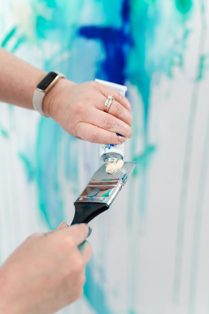 artist painting a wall with blue and green tones during an online coach branding session