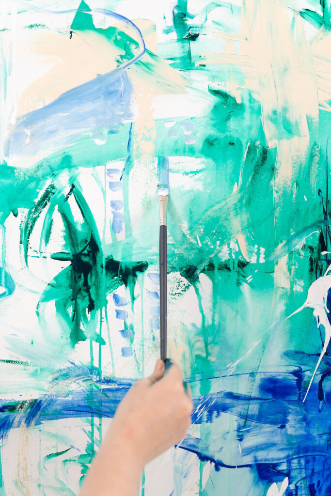 artist painting a wall with blue and green tones during an online coach branding session