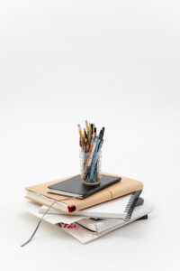 books stacked on top of each other with a pencil holder on top