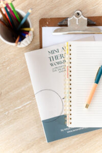 aerial image of a table with notebooks, papers, and writing tools on it