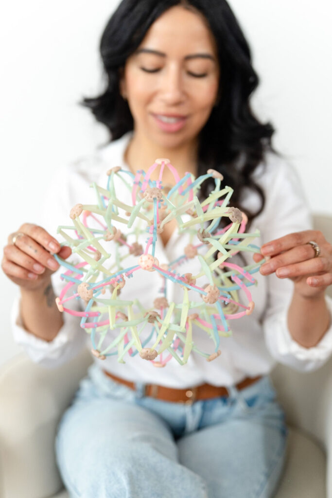 woman in blouse holding tool used for art therapy