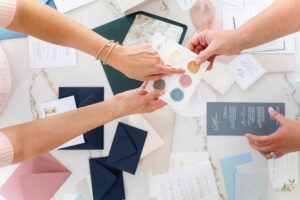 overhead image of women touching different stationary during a branding subscription