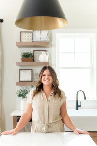 woman in neutral clothes smiling while standing by the kitchen island during a branding subscription