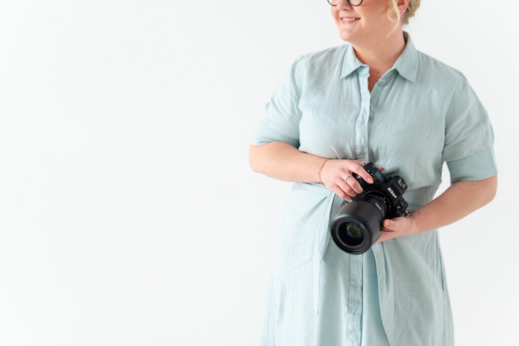 Professional brand photo of a PA wedding photographer holding her NIkon DSLR camera
